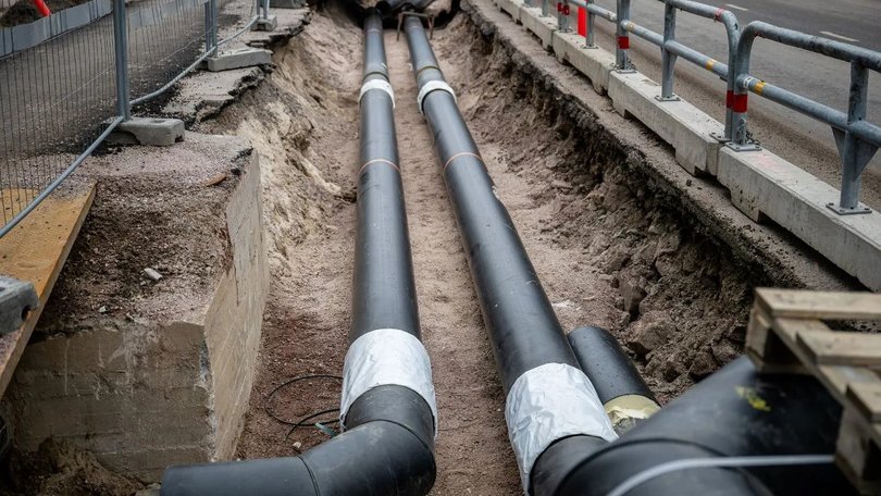large-black-underground-pipes-being-installed-excavated-trench-construction-site
